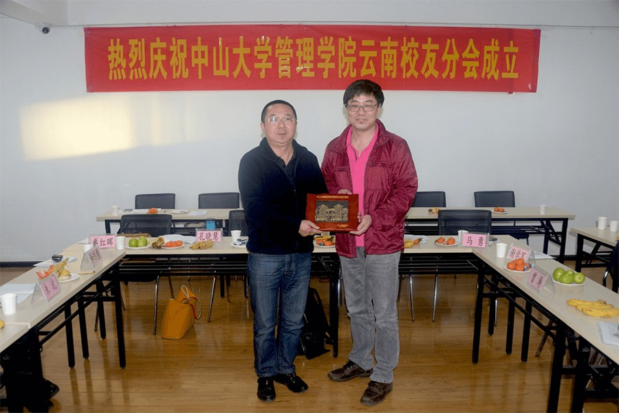 On behalf of Business School, secretary Tan Jingsong presented souvenir to the Yunnan Alumni Association.